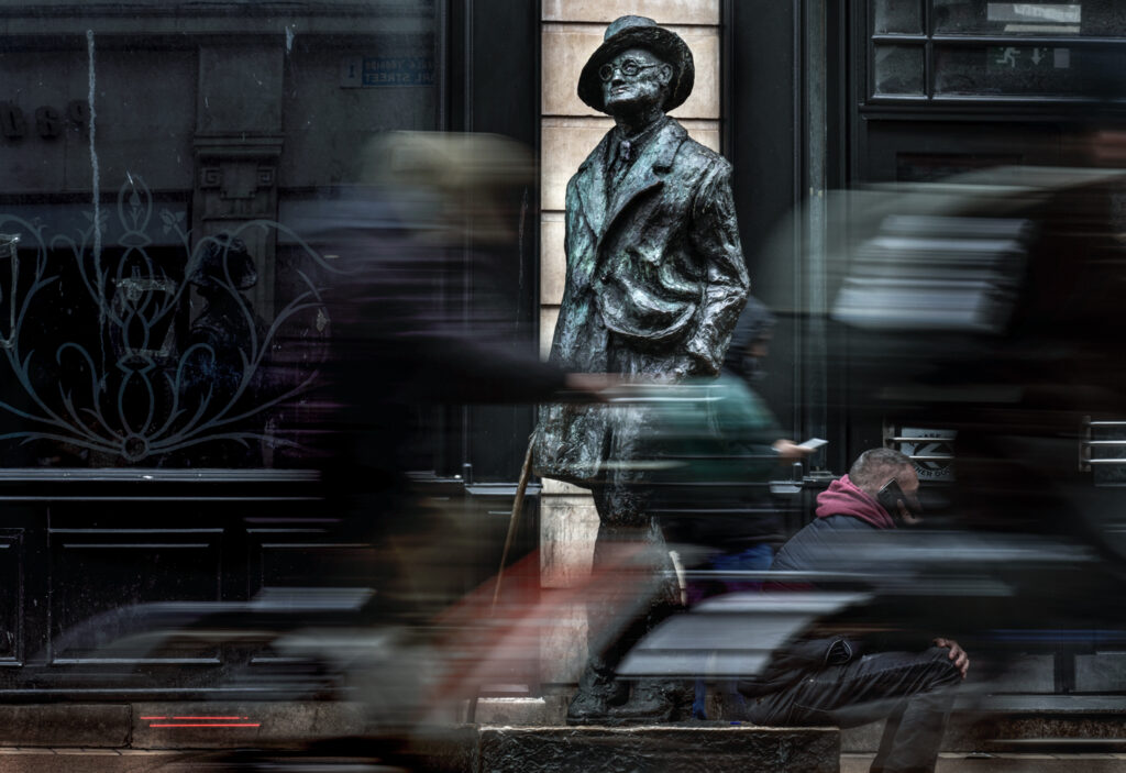 Pedestrians pass by the James Joyce statue on North Earl Street in Dublin, Ireland.